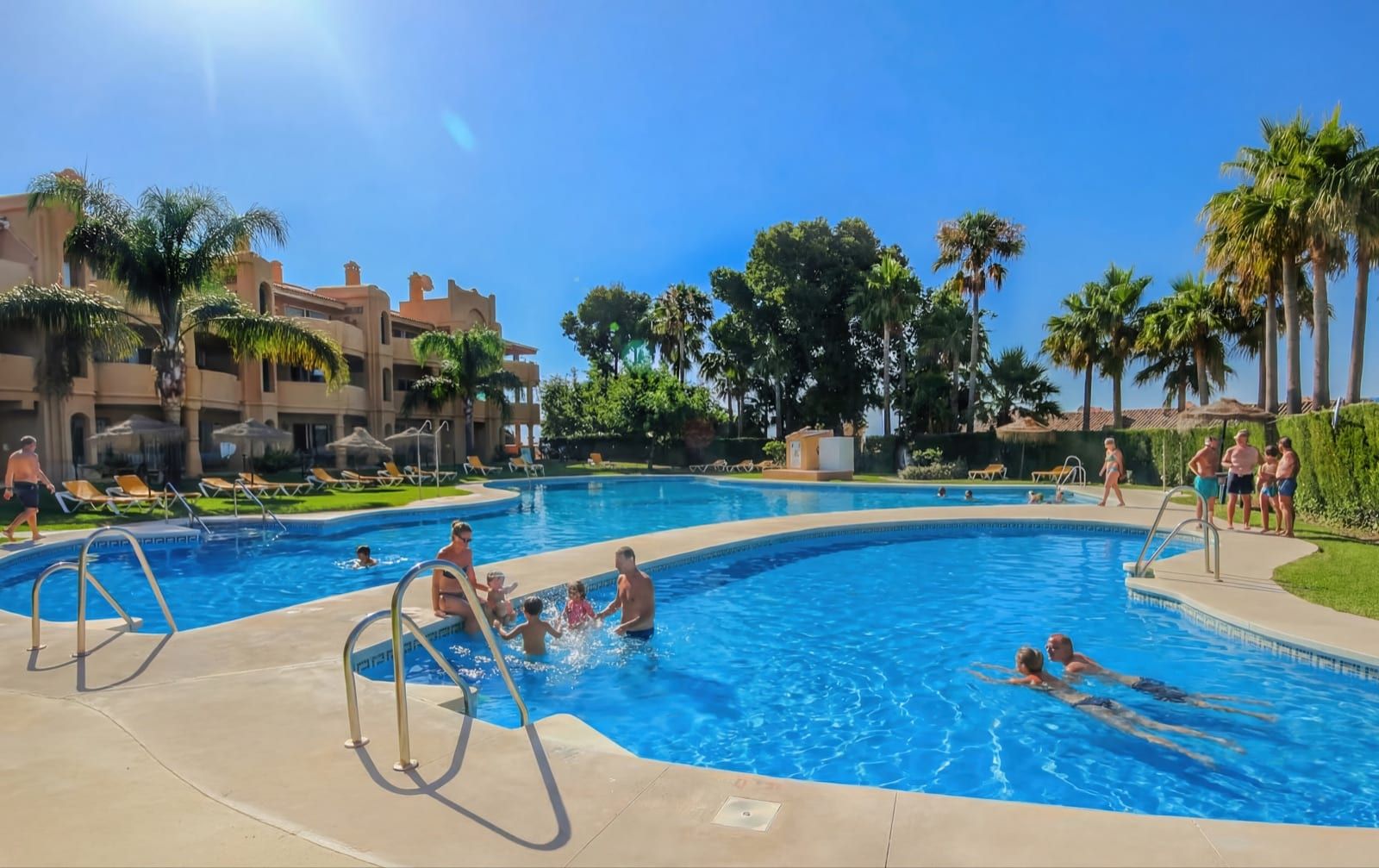 Community pool at La Quinta Ca5a, surrounded by palms