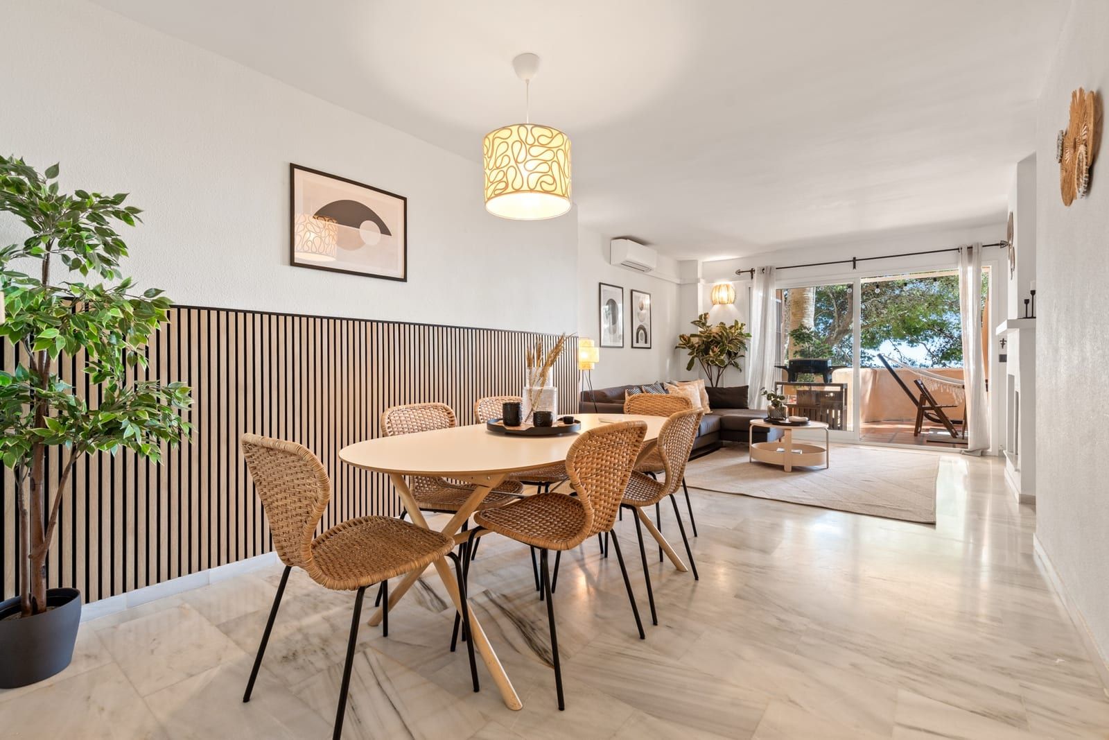 Open-plan dining and living room at La Quinta Ca5a with rattan chairs